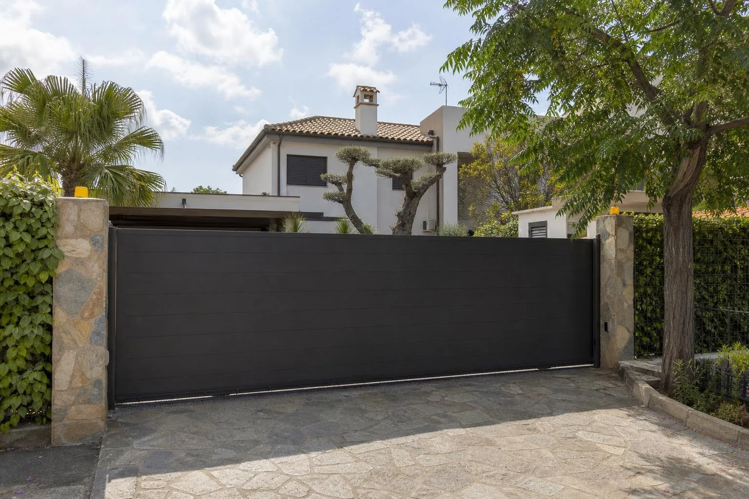 Puerta corredera metálica cerrando el acceso de una vivienda moderna